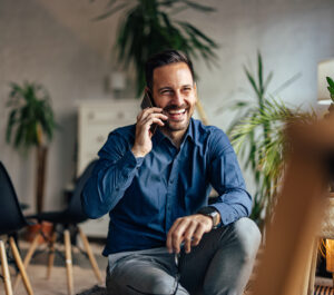 Businessman talking with someone over the phone, being at the office.